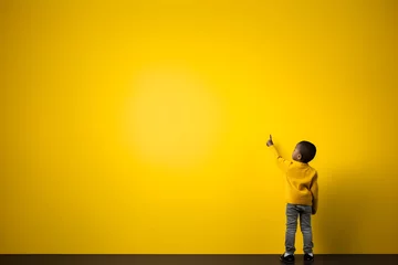 Foto op Plexiglas Kind vor buntem/monochromen Hintergrund das auf etwas zeigt © Seegraphie