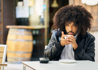 Portrait of a man with afro hair having a hot coffee on a terrace