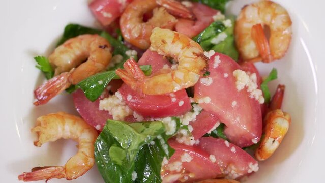 Serving fresh vegetable salad with cuscus and shrimps