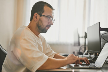 Portrait professional man programmer working concentrated on computer in diverse offices. Modern IT...