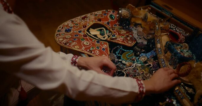 man pleasant viewing chest with jewelry and treasures, closeup view of hands, 4K, Prores