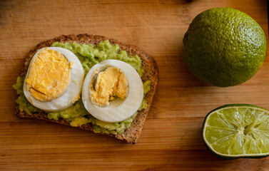  avocado toast topped with a perfectly boiled egg, presented on a rustic wooden board