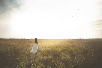 woman walking in the middle of a meadow, life concept