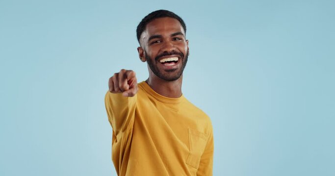 Face, wink and man with hand pointing at you in studio with choice, selection or offer on blue background. Opportunity, happy and portrait of male model with emoji for join us, deal or invitation