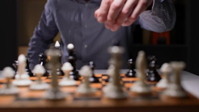 strategy and success, young man plays chess, carefully considers his move, close-up