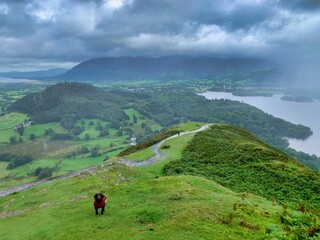 hiking walking up cat bells with dog in wet and foggy weather in the Lake District
