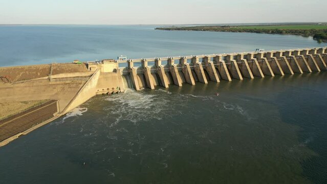Large flock of swallows fly above turbulent water released from sluice gate in Bloemhof Dam wall