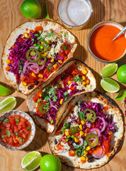 Mexican street Tacos with veggies and salsa on the  wooden tray. Vegan Tacos, plant based diet: with black beans, corn, jalopeno peppers, red cabbage. Top view - 656434578