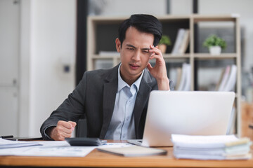 Asian businessman thinking hard about online solution looking at laptop screen Serious Asian businesswoman worried focused on solving difficult computer tasks
