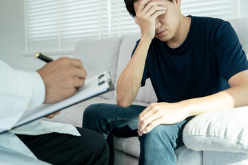Fototapeta premium man with mental health problems is consulting. psychiatrist is recording the patient's condition for treatment. encouragement, love and family problem, bipolar , depression patient, protect suicide