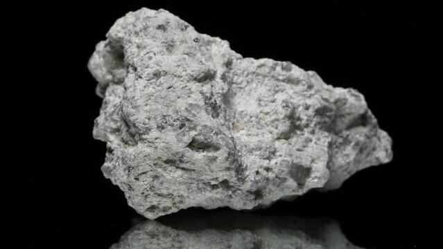 Kaolinite (clay silicate mineral) specimen rotating slowly against a black background.