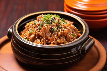 bbq pulled pork with sesame seeds in a terracotta bowl