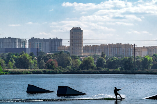 City houses on the far shore of the lake where a man is wakeboarding