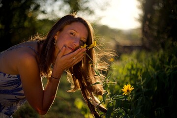 Femme sent une fleur jaune nature campagne