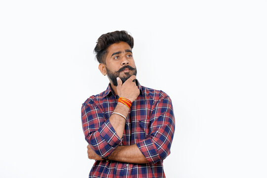 Young man with thoughtful expression in casual clothing considering a question. smiling and looking thoughtful.