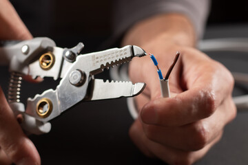 The use of the stripper cutter tool to strip the end of the electrical wire - obrazy, fototapety, plakaty