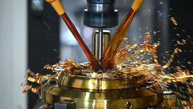 Slow motion scene the CNC milling machine cutting the shell mold parts with oil coolant method.