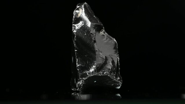Black Obsidian (from Mexico) Natural volcanic glass, sample rotating slowly against a black background.