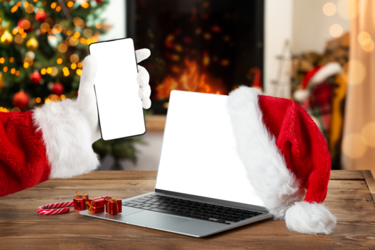 Notebook and smartphone with blank screen on rustic Christmas interior with fireplace. Christmas online shopping. - Powered by Adobe