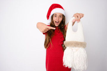 Cute little girl in santa hat standing isolated over white background.