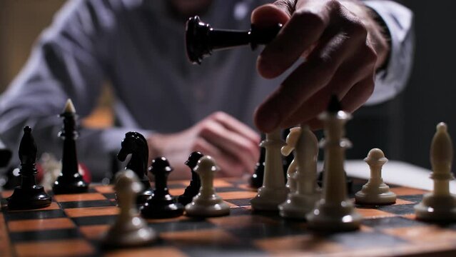 strategy for success, businessman rearranges chess pieces on chessboard then scatters pieces, close-up