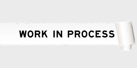 Ripped gray paper background that have word work in process under torn part