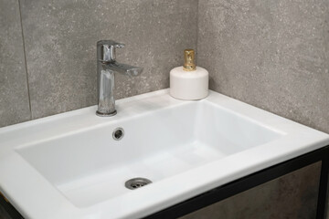 Modern sink. Stylish white sink with Faucets in modern interior. Water tap made of chrome material. Domestic Appliances. Gray bathroom. household equipment. Water Tap. Contemporary style