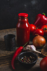 Ketchup in a jar. Tomato sauce on a dark background