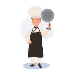 Cute Child Chef in Chef's Hat and Apron is showing frying pan. Ready to cook.
