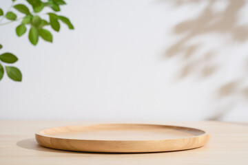 Minimal wood plate podium table top blurred green leaf plant on white space nature...