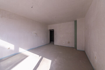 New empty room under construction. Plaster walls. New home. Concrete walls. Interior renovation.