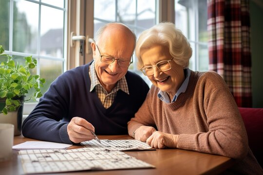 An elderly couple solves a  crossword together at home