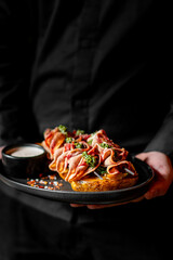 chef or waiter hold plate of beef tongue with potatoes and mushroom sauce on plate