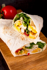 Tortilla wrapped with fried chicken meat, vegetables and corn.