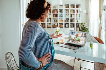 Young pregnant woman consulting her doctor about medication on a video call from home
