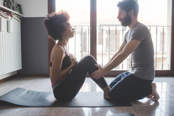 Multiethnic couple at home practicing sport doing fitness yoga - obrazy, fototapety, plakaty