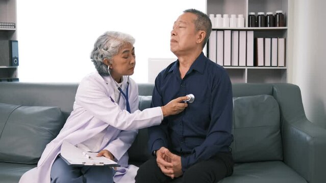 female doctor use stethoscope examine mature male patient heart rate at consultation in hospital. Woman nurse or GP use stethoscope listen to senior man heartbeat in clinic.