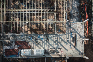 Aerial View Construction Site. Workers Fixing Grid Foundation Bars. Progress and Activity on the Rooftop.