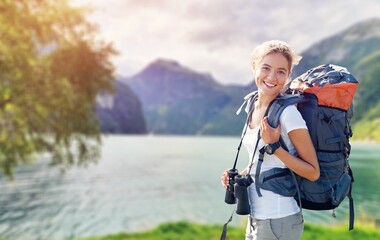 Person stands on a mountain peak looking in beautiful view