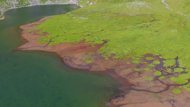 Beautiful green lake lost in mountains in summer - Tignes by drone