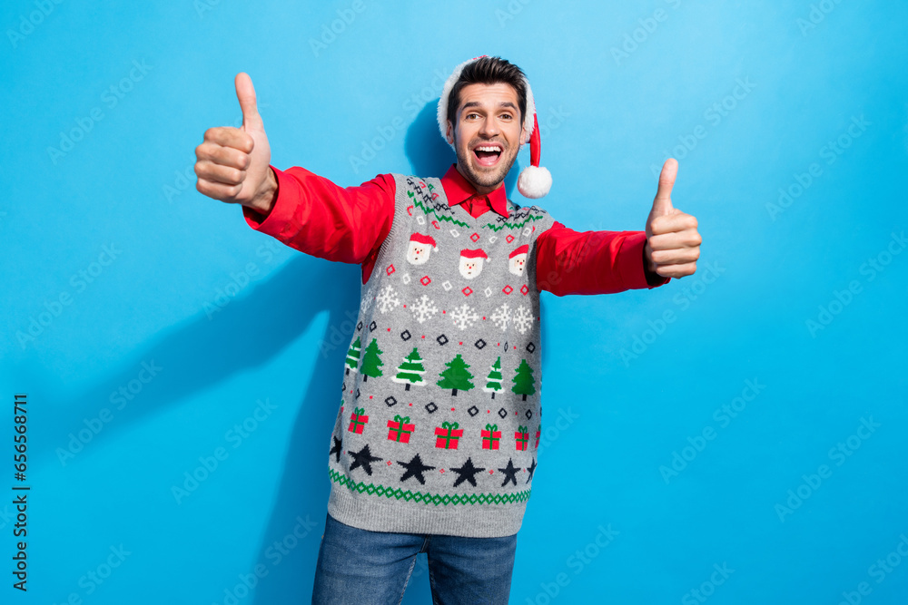 Sticker Photo portrait of handsome young guy show excited double thumb up dressed x-mas print vest hat outfit isolated on blue color background