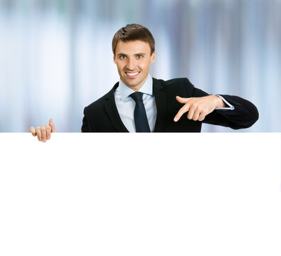 Concept photo - business man professional manager confident suit. Businessman stand behind, hang over, show point finger empty white banner signboard. Blurred office background