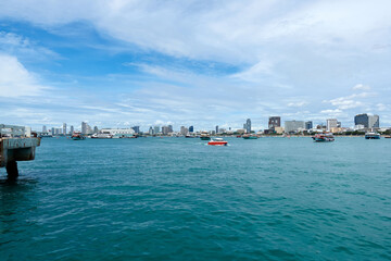 Landscape of Pattaya Bay and Pattaya city during the daytime with speedboat tour boats moored in the bay.