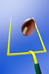 Field Goal or Extra Point in American Football looking up at the goal post as the ball flies through the air