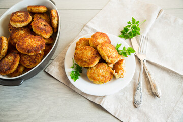 Cooked fried fish cutlets in a plate with herbs.