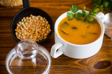 Cooked dried pea puree soup with mushrooms in a bowl .
