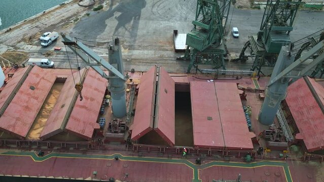 Bulk carrier cargo ship closes hold full of grain before shipping, aerial view