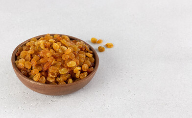 Bowl of golden raisins on a white background. Copy space.