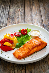 Seared salmon steak with grilled bell pepper and mayonnaise on wooden table
