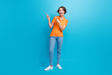 Fototapeta na wymiar Full size photo of astonished ecstatic girl dressed stylish polo jeans indicnating at offer empty space isolated on blue color background